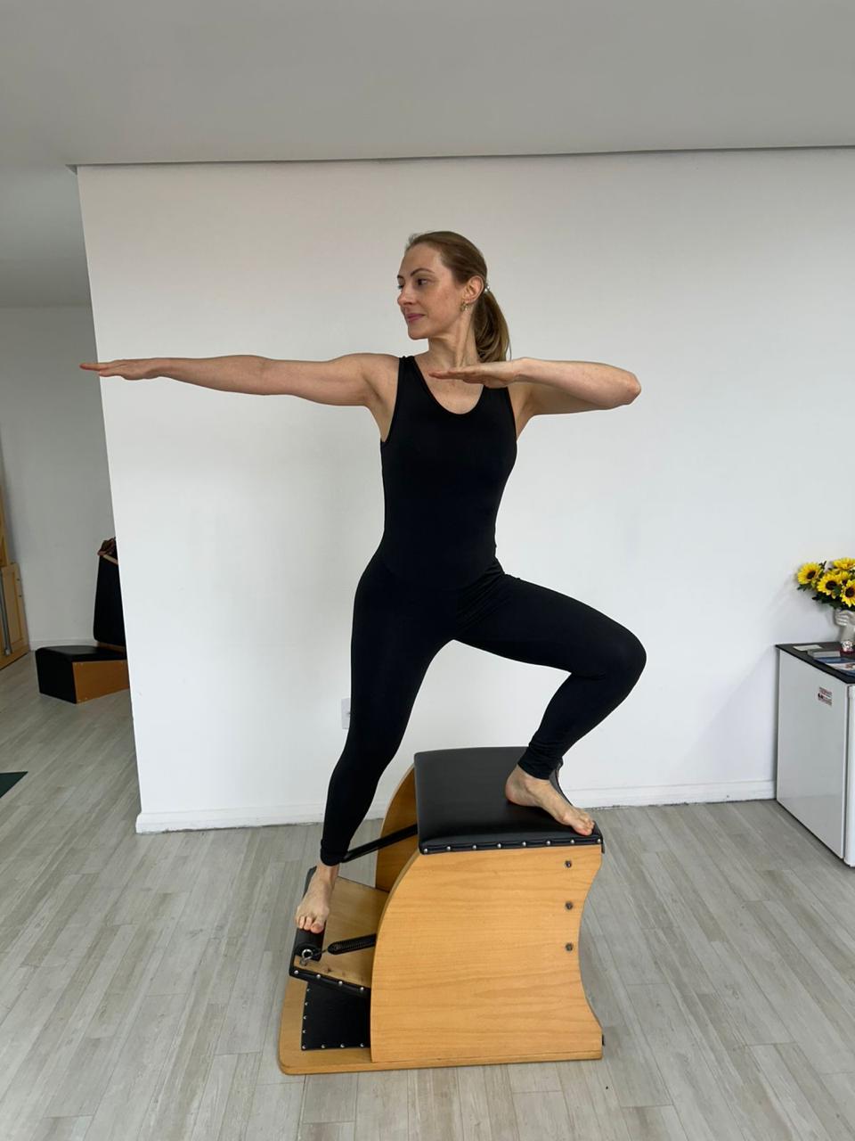Debora em exercício de equilíbrio e força no Pilates Chair.